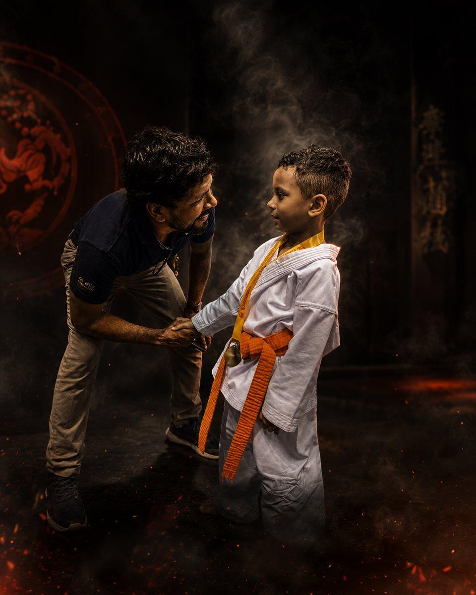 Shihan R.J. Edward tying an orange belt for a young student